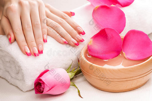 用芳香的玫瑰花瓣和毛巾修指甲。水疗中心
