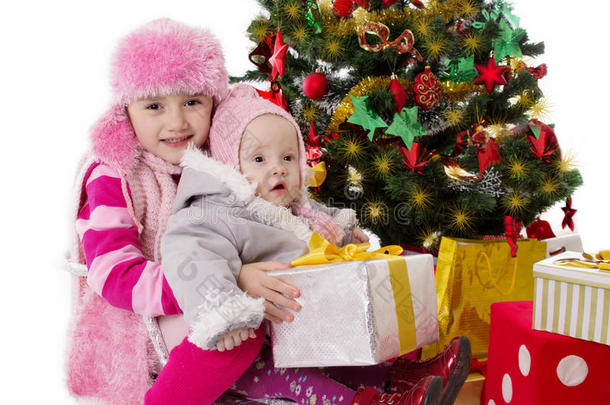 坐在圣诞树下拿礼物的姐妹们
