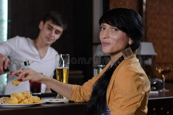 在酒吧吃零食的年轻女子