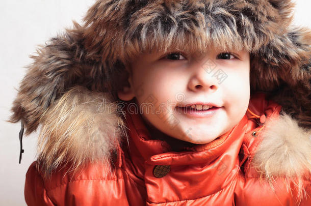带着皮帽<strong>和橘色</strong>冬天的微笑的孩子夹克。时尚男孩