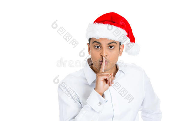 戴圣诞老人帽，手指放在嘴唇上的帅哥