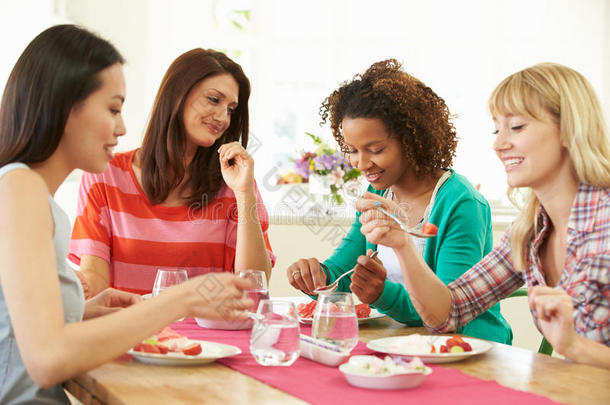 围坐在桌边吃甜点的一群妇女