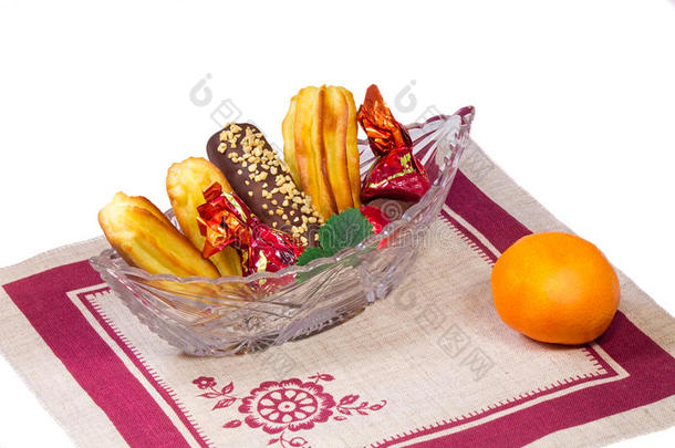 <strong>水晶花</strong>瓶里的蛋糕和糖果，橘子，w上的餐巾