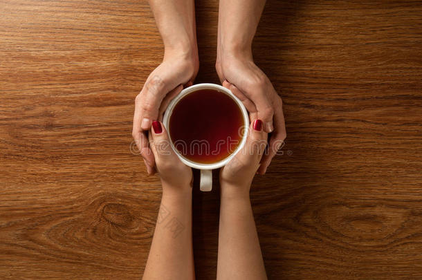 女人和男人在木桌上端着热茶