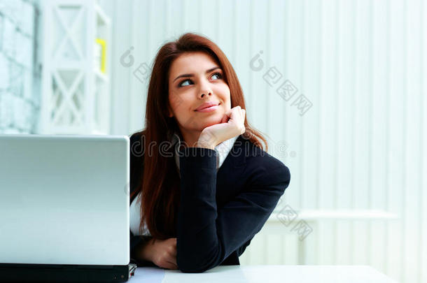 年轻快乐的女商人坐在自己的工作场所，看着自己的文案