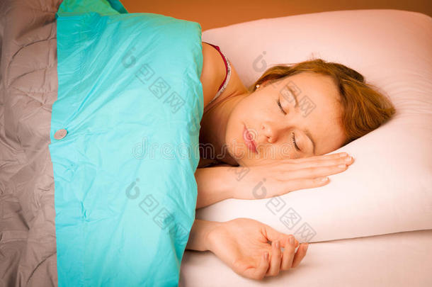 躺在床上的枕头上，裹着毯子的女人