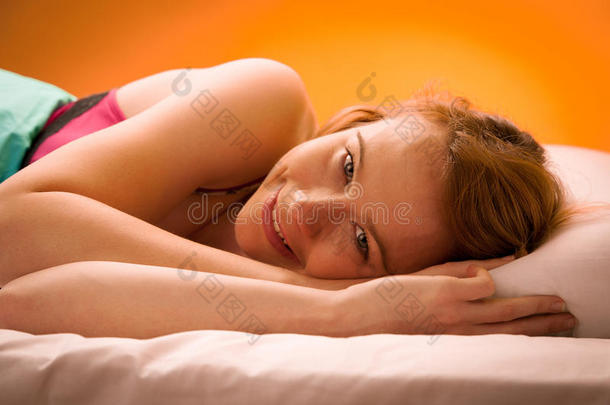 躺在床上的枕头上，裹着毯子的女人