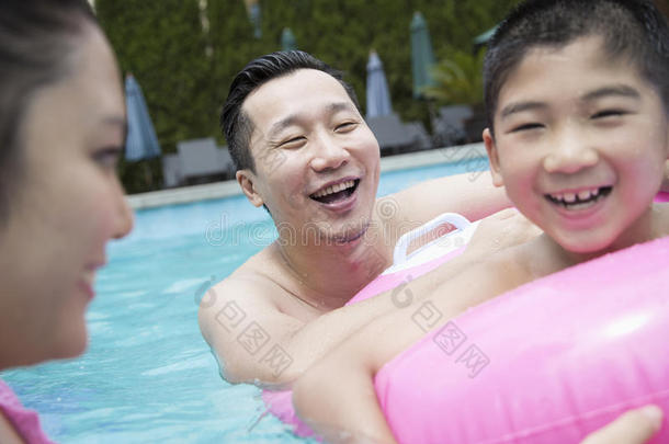 微笑的爸爸、妈妈和儿子在游<strong>泳池里玩耍</strong>