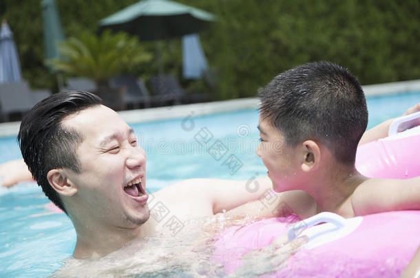 微笑的父子在<strong>泳池里玩耍</strong>