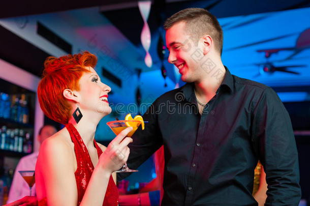 在酒吧或俱乐部喝鸡尾酒的年轻夫妇