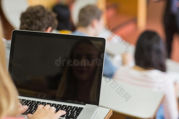女教师和学生在讲堂使用笔记本电脑