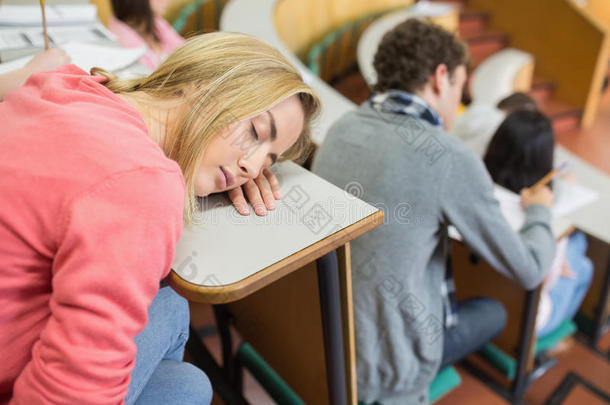 睡着的女生和坐在讲堂里的学生