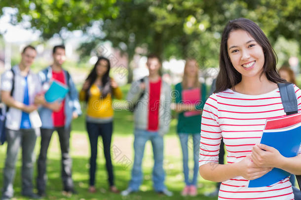 公园里抱着迷离学生的书的女大学生