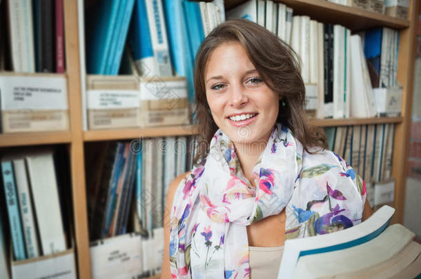 图书馆书架旁微笑的女学生