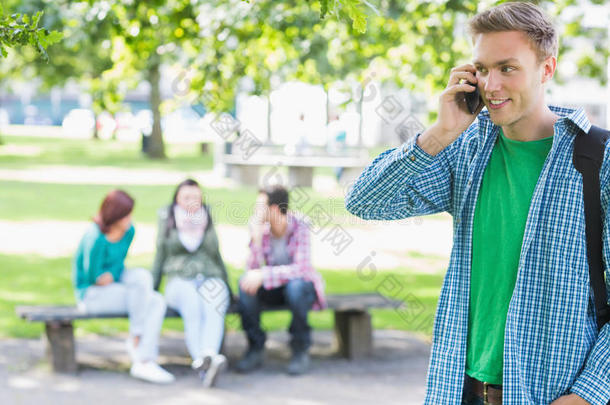 大学生在公园里和迷离的学生打手机