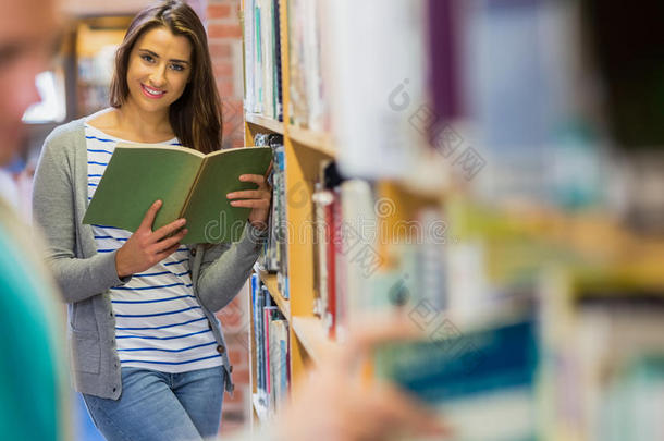 学生在图书馆书架旁看书
