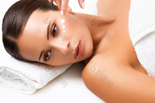 特写镜头：一位年轻女子正在接受水疗。化妆霜
