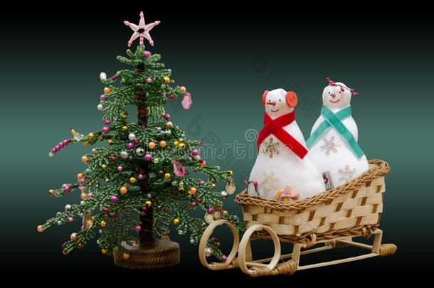 手工制作的软玩具雪橇上的两个雪人和新年树
