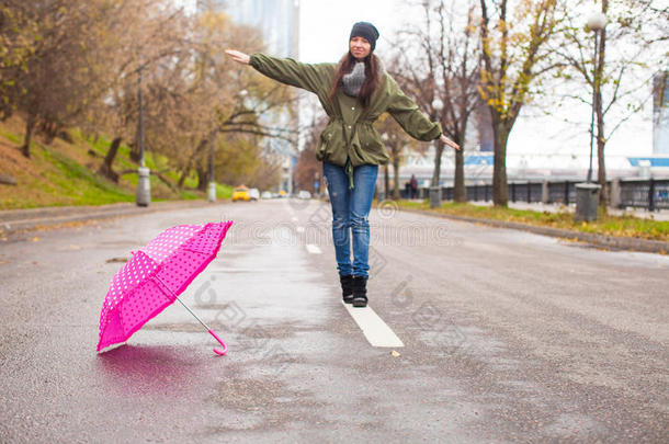 秋雨中撑伞散步的年轻女子