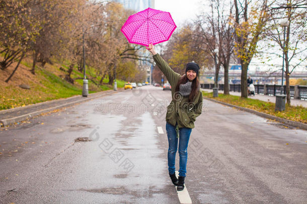 秋雨中撑伞散步的年轻女子