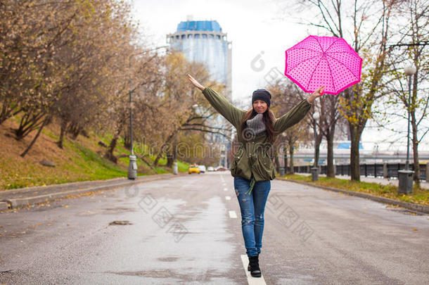 秋雨中撑伞散步的年轻女子