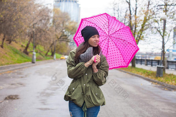 秋雨中撑伞散步的年轻女子