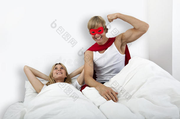 穿着超级英雄服装的男人和女人躺在床上的肖像