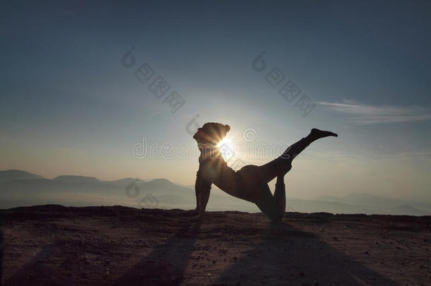 年轻女子早上在悬崖上练瑜伽