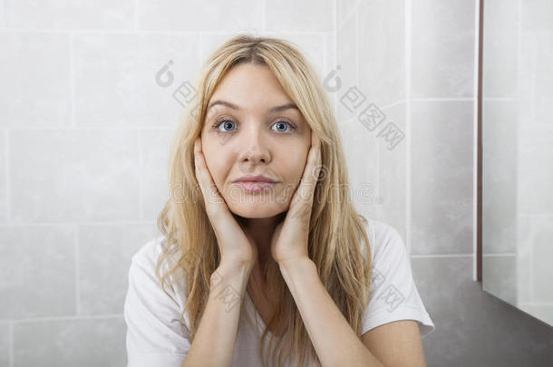 女青年在浴室摸脸颊的画像