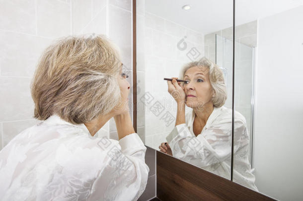 在浴室看镜子的老女人<strong>涂抹</strong>眼线<strong>笔</strong>