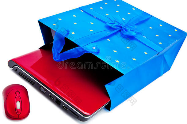 红色的<strong>笔记本</strong>电脑和一只电脑<strong>鼠标</strong>被包装成礼品包