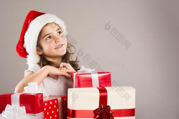 带圣诞礼物的圣诞帽小女孩
