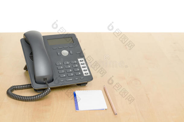 电话放在桌子上，记事本放在木桌上