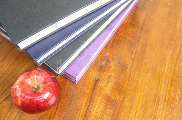 木制<strong>桌面</strong>上的红苹果和旧书