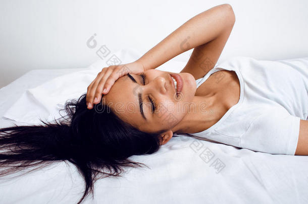 漂亮的黑发女人躺在床上，<strong>睡不着</strong>觉