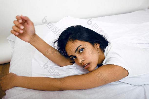 漂亮的黑发女人躺在床上，睡不着觉