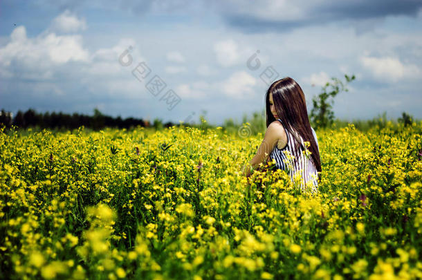 幸福的女人坐在黄灿灿的花坛上