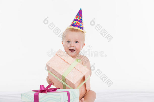 快乐美丽的宝宝戴着派对礼帽拿着礼物盒。