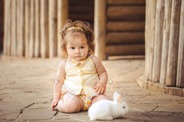 在<strong>村子</strong>里玩兔子的小女孩。户外。夏日肖像。