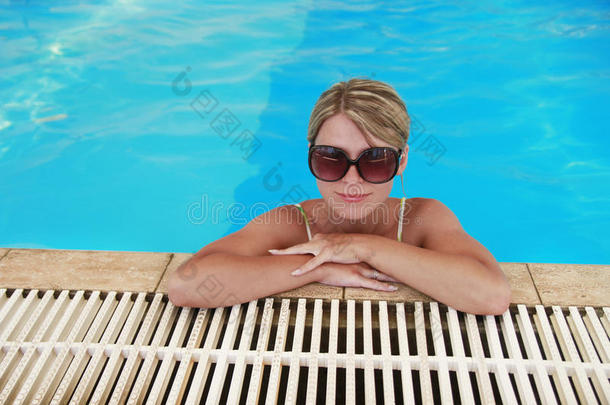 女孩在蓝色水池里戴眼镜，防晒