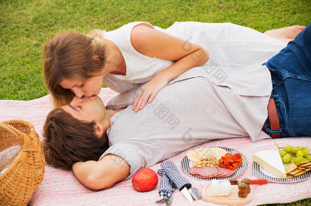 迷人的情侣在浪漫的午后野餐亲吻