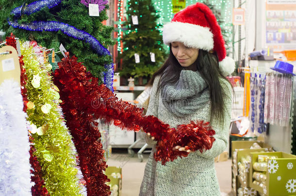 戴圣诞帽的年轻女子在挑选装饰品