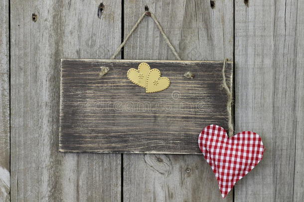 挂在木门上的空白木牌，上面有方格布和金色的心形图案