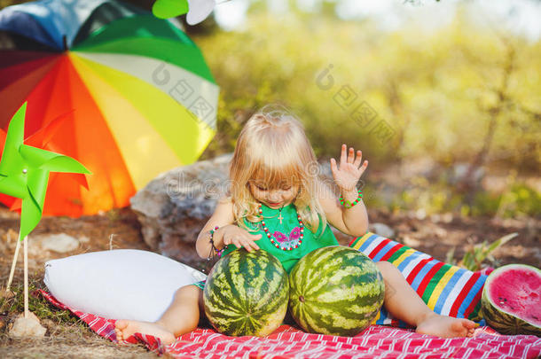可爱的小女孩在夏天的公园户外玩西瓜