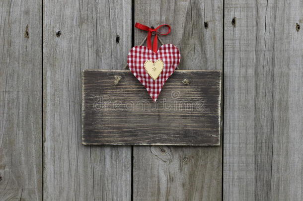 木质背景上挂着红色格子和金色心形图案的空白木制标牌