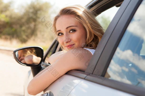 坐在车里拿钥匙的微笑的年轻女子