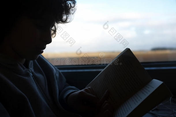 男孩在火车旅行中读了一本书