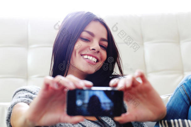 微笑的女人用智能手机自拍