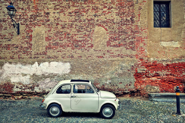 靠着砖墙的旧小汽车。