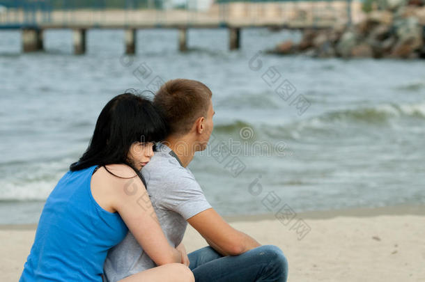 一对<strong>恩爱</strong>的年轻<strong>夫妇</strong>坐在海边
